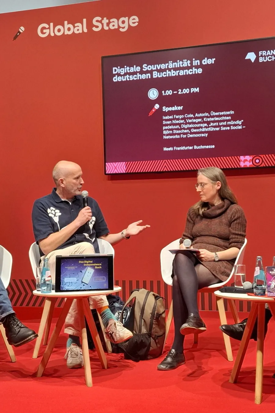 Podiumsgespr&auml;ch vor einem Bildschirm auf der Global Stage der Buchmesse Frankfurt 2026.